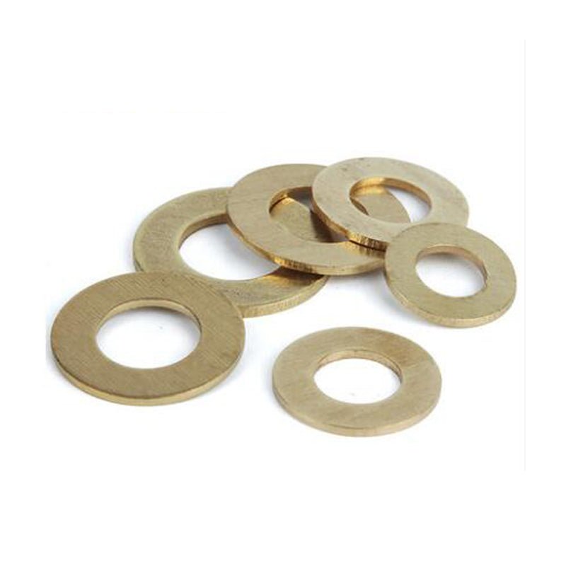 A scattered group of brass flat washers displayed on a white background