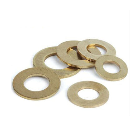 A scattered group of brass flat washers displayed on a white background